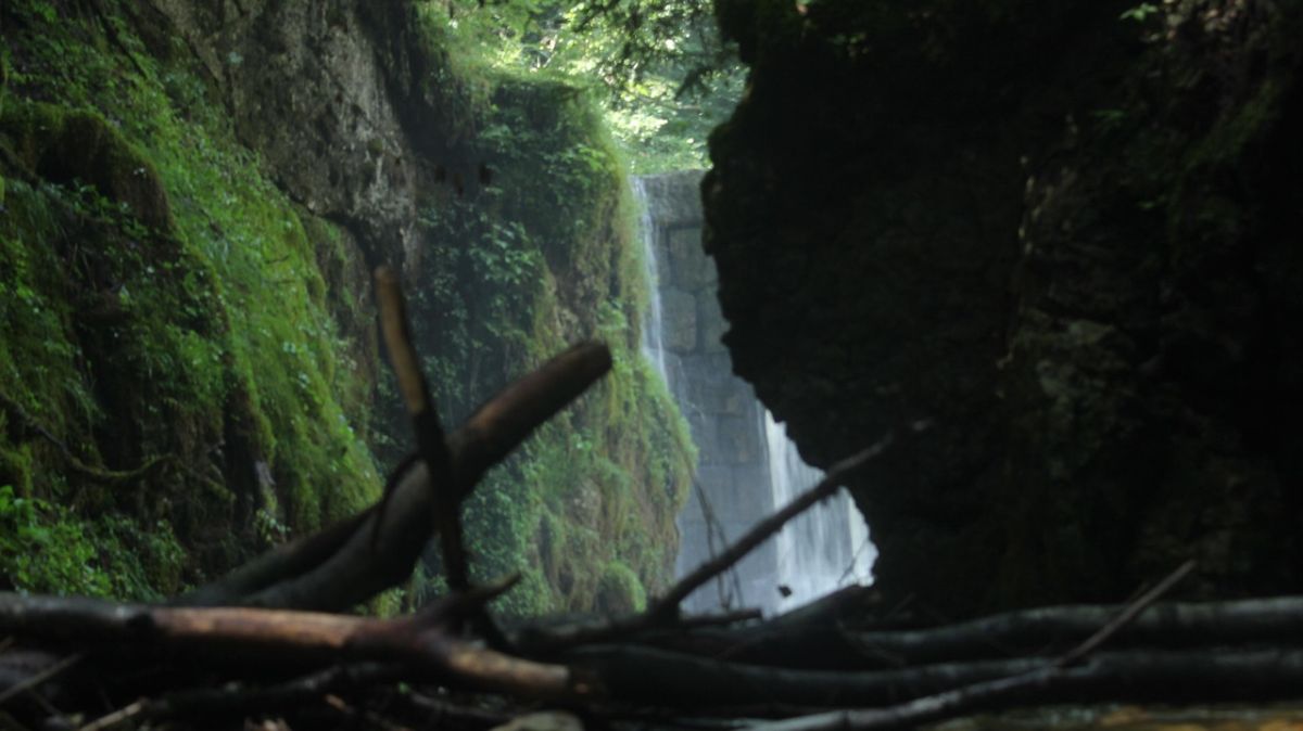 rechte Seite des Bildes dunkel, links hell und ein Wasserfall, so wie 2 Ansichten in einem Bild.