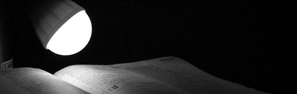 Eine Lampe beleuchtet den Bibeltext.