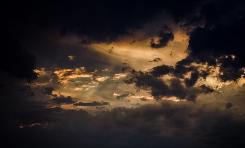 Sonne hinter sich verdunklenden Wolken.