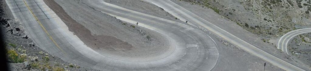 Nahaufnahme der chilenischen Gebirgsstraße mit scharfen Kehren und Wendungen. Christen bleiben optimistisch, weil sie letztlich auf den unsichtbaren Jesus sehen und an ihn glauben, den sie nicht optisch sehen können.