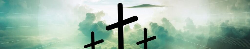 Drei Holzkreuze vor strahlendem Himmel.