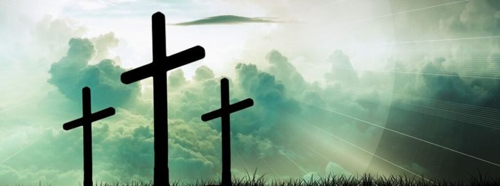 Strahlender Hintergrund durch Sonnenstrahlen, im Vordergrund drei Holzkreuze, von denen das mittlere das kreuz Jesu Christi symbolisiert. Er ist der König der Juden.