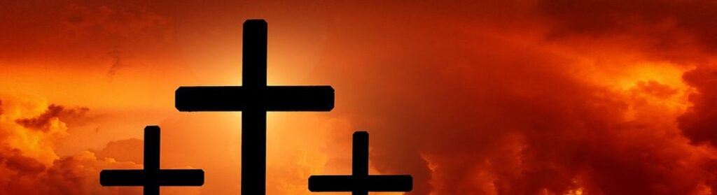 Drei Holzkreuze vor dem orangeroten Himmel: Blogthema, Jesus, der König der Juden starb am Holzkreuz.