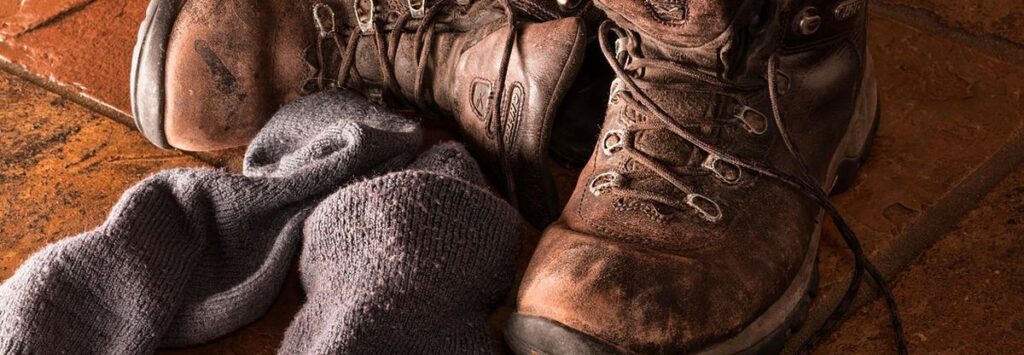 Zwei abgelegte Stiefel und Socken daneben.