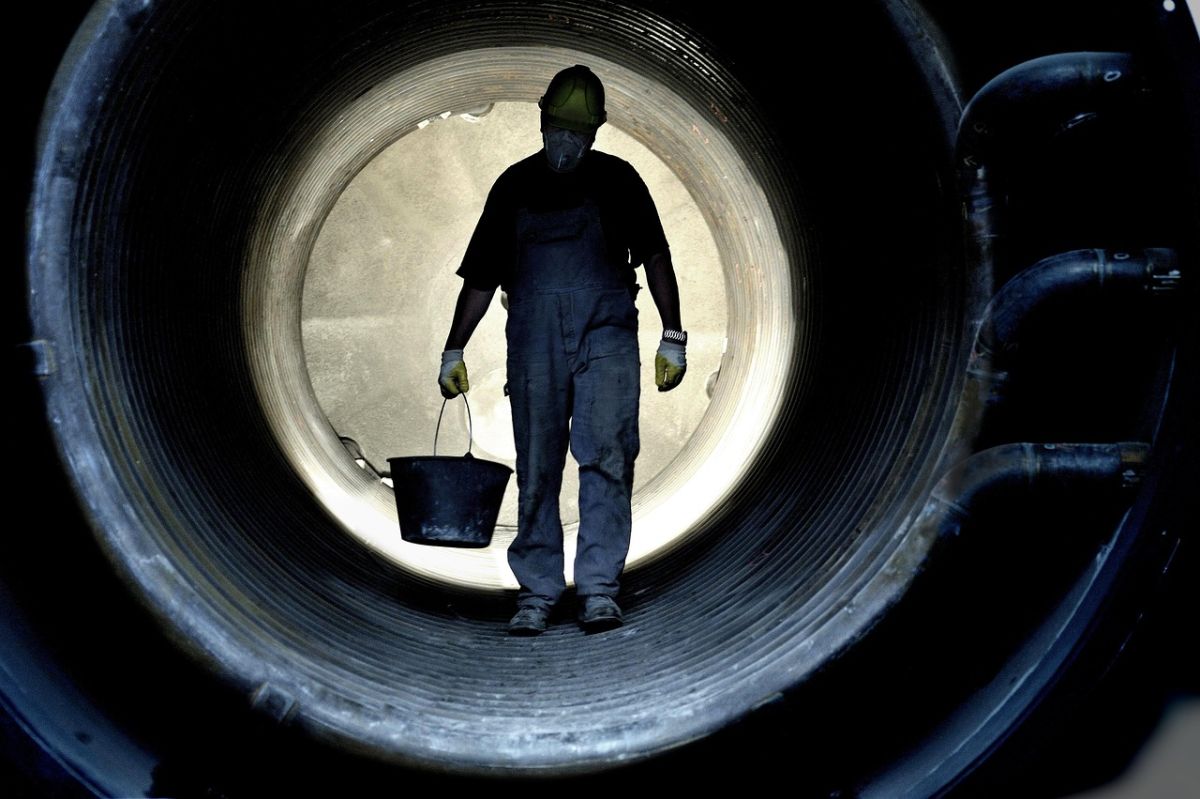 Arbeiter im Tunnel mit Eimer in der Hand.